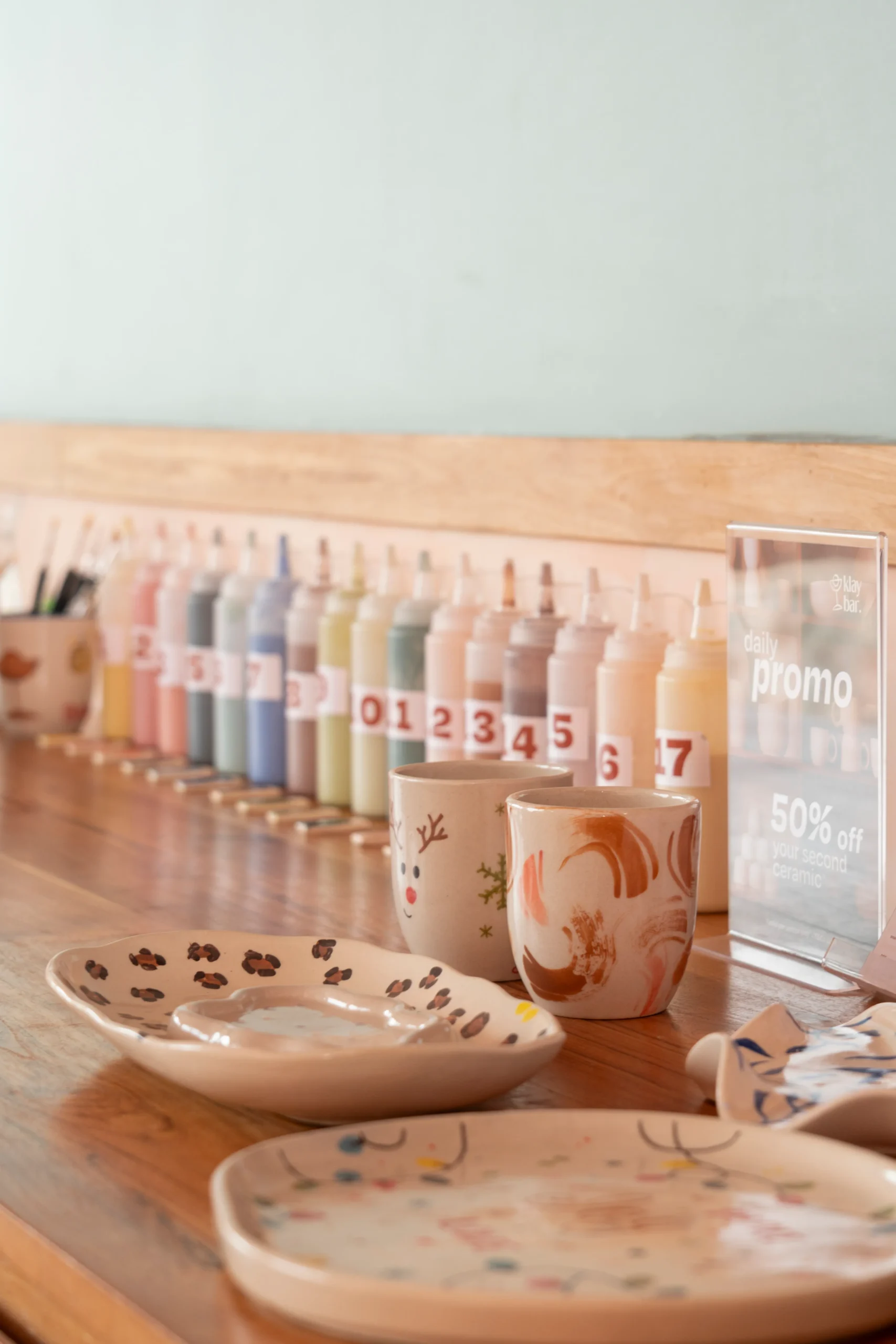 glaze colour bar and handpainted ceramics on wooden cabinet